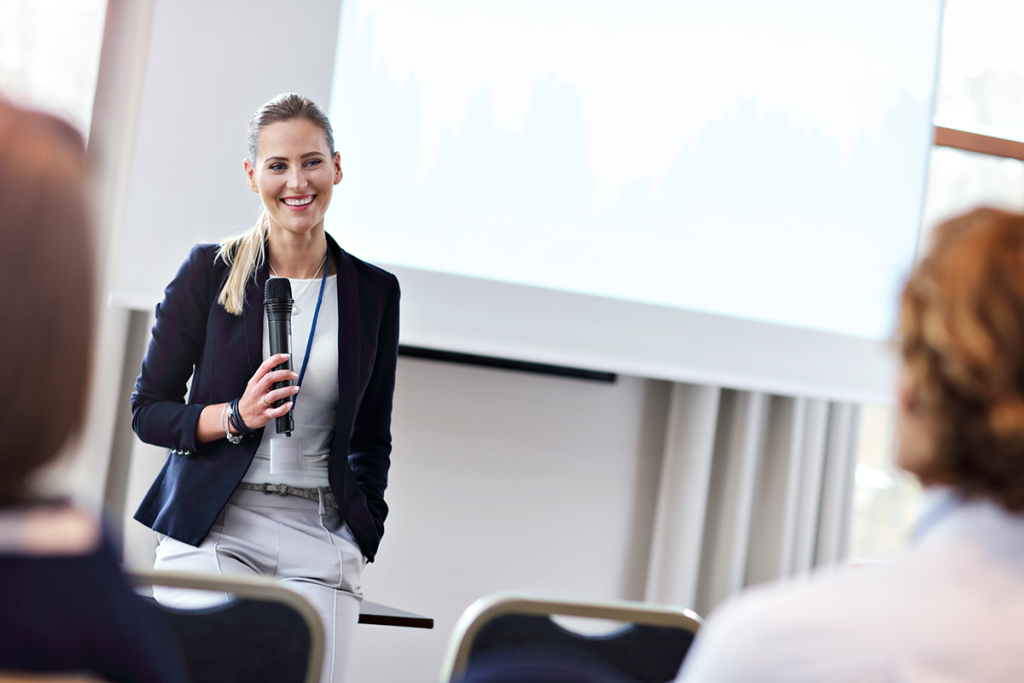 A woman looking comfortable at the front of a room - representing Nerve Strategic's Executive Presence