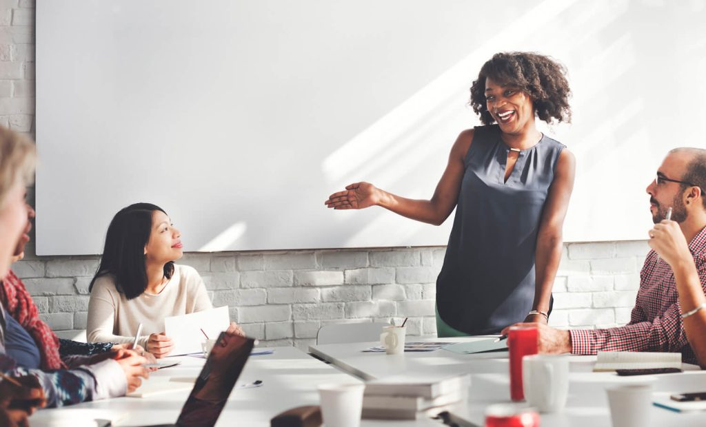 A woman presenting at a whiteboard with great business presence
