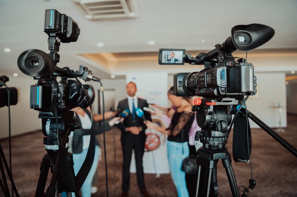 A man speaking to several people and video cameras - to represent Nerve Strategic's Media Training